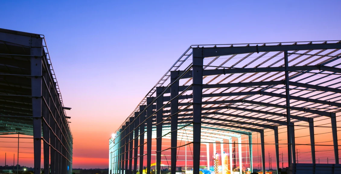 Building structure silhouetted against sunset